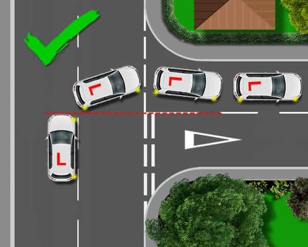 Top-down diagram with a green tick showing the correct point of turn: a learner car drives forward to the centre point of the side road before steering, so it ends up in the correct lane of the new road without cutting the corner.